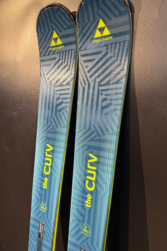 Pair of blue Fischer skis with yellow text on a dark background
