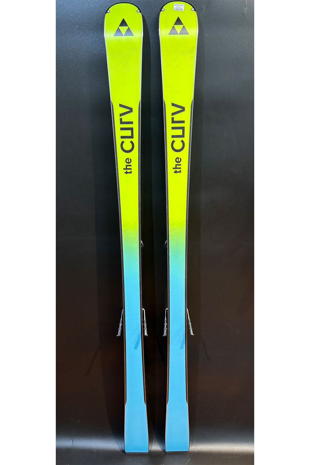 Two skis with a gradient color from green to blue on a dark background