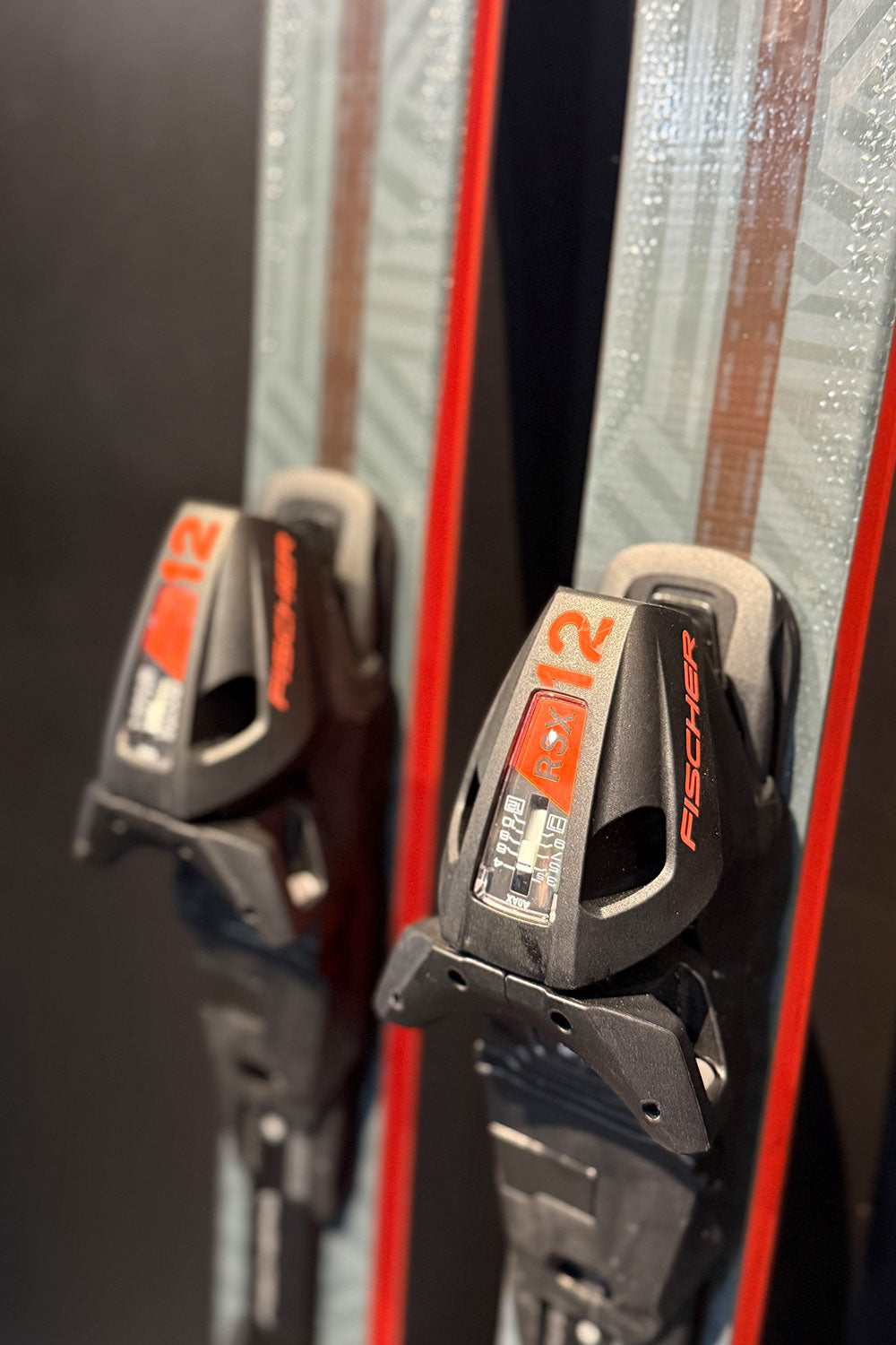 Close-up of Fischer ski bindings on a ski with a blurred background