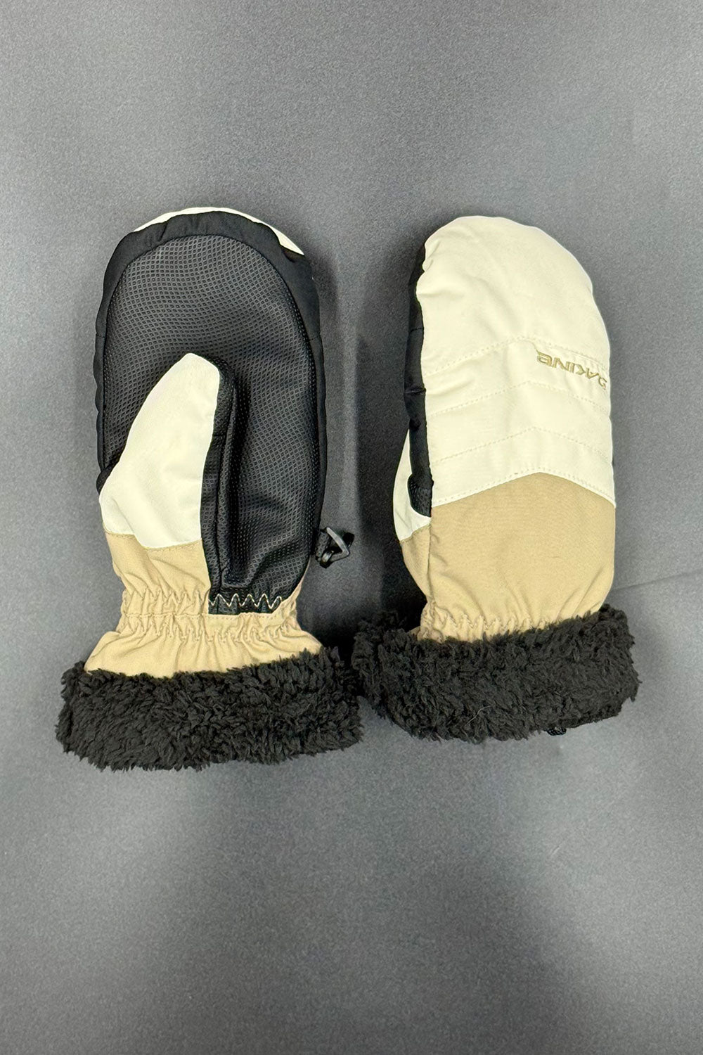 Pair of black and beige mittens on a gray background