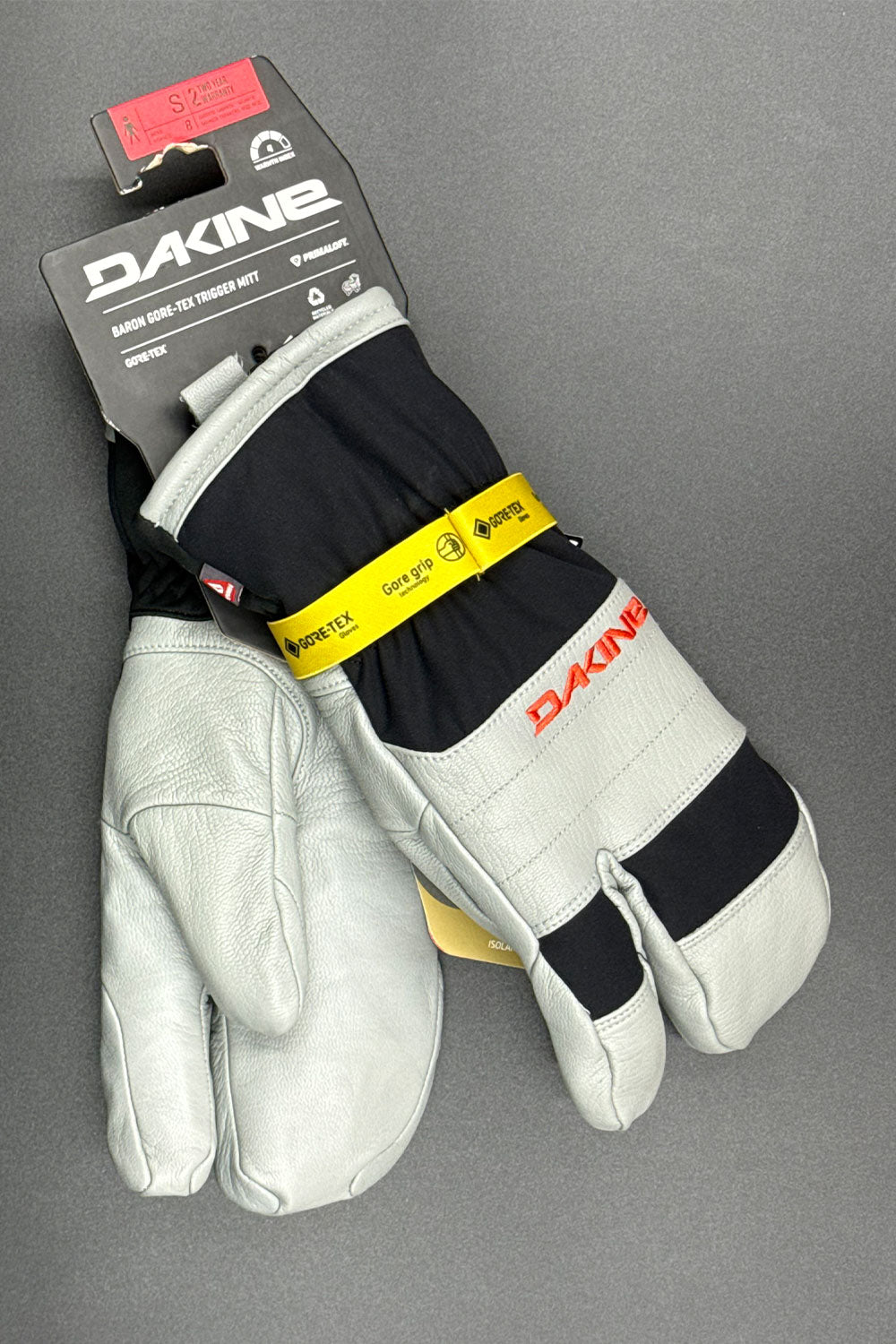 Pair of gloves with Dakine branding on a gray background