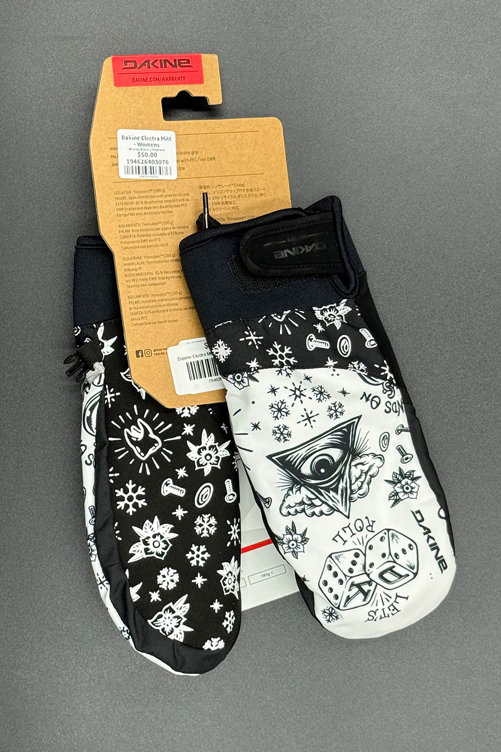 Black and white patterned mittens with a visible brand label on a gray background