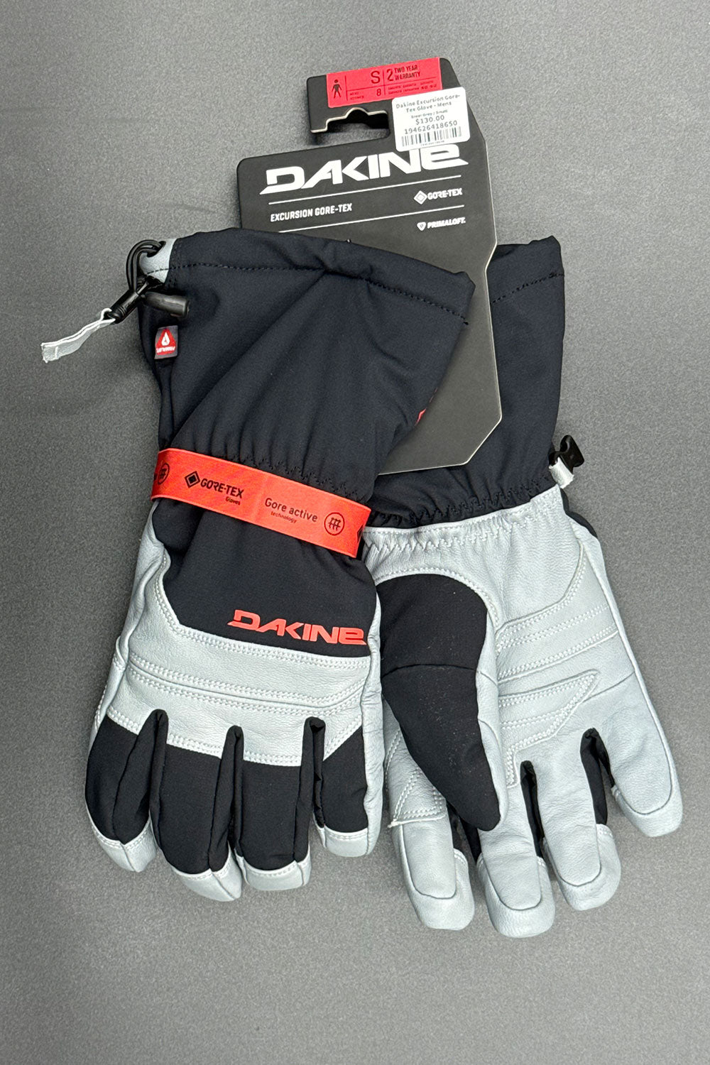 Pair of black and gray gloves with Dakine branding on a gray background