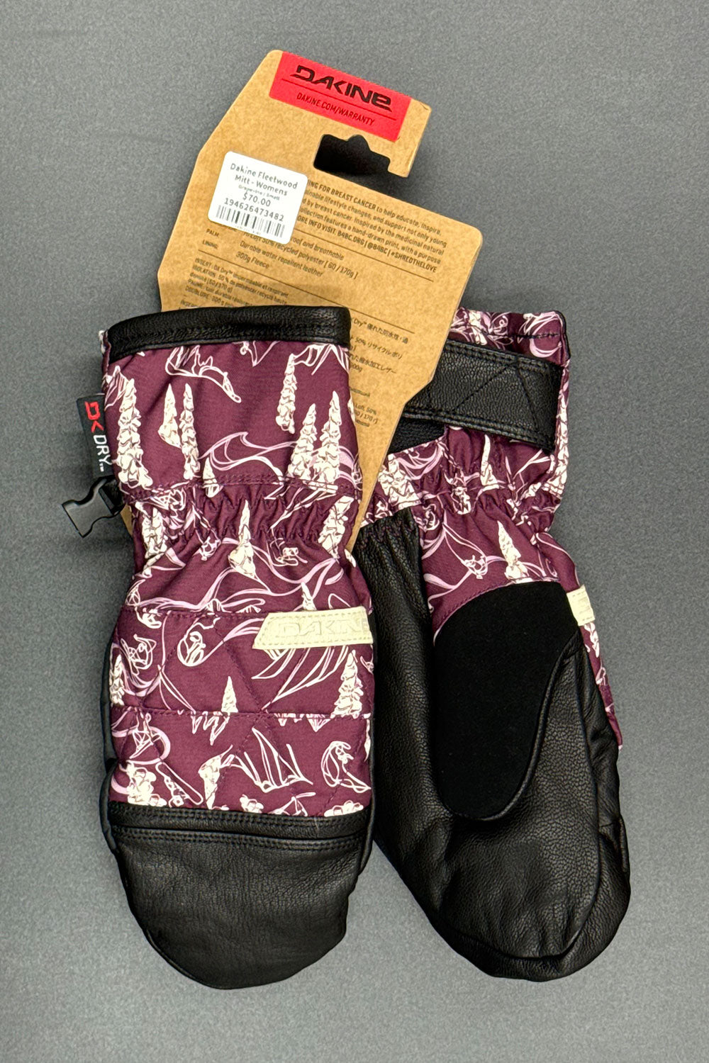 Pair of purple patterned gloves with a black interior on a gray background, featuring a Dakine brand tag.
