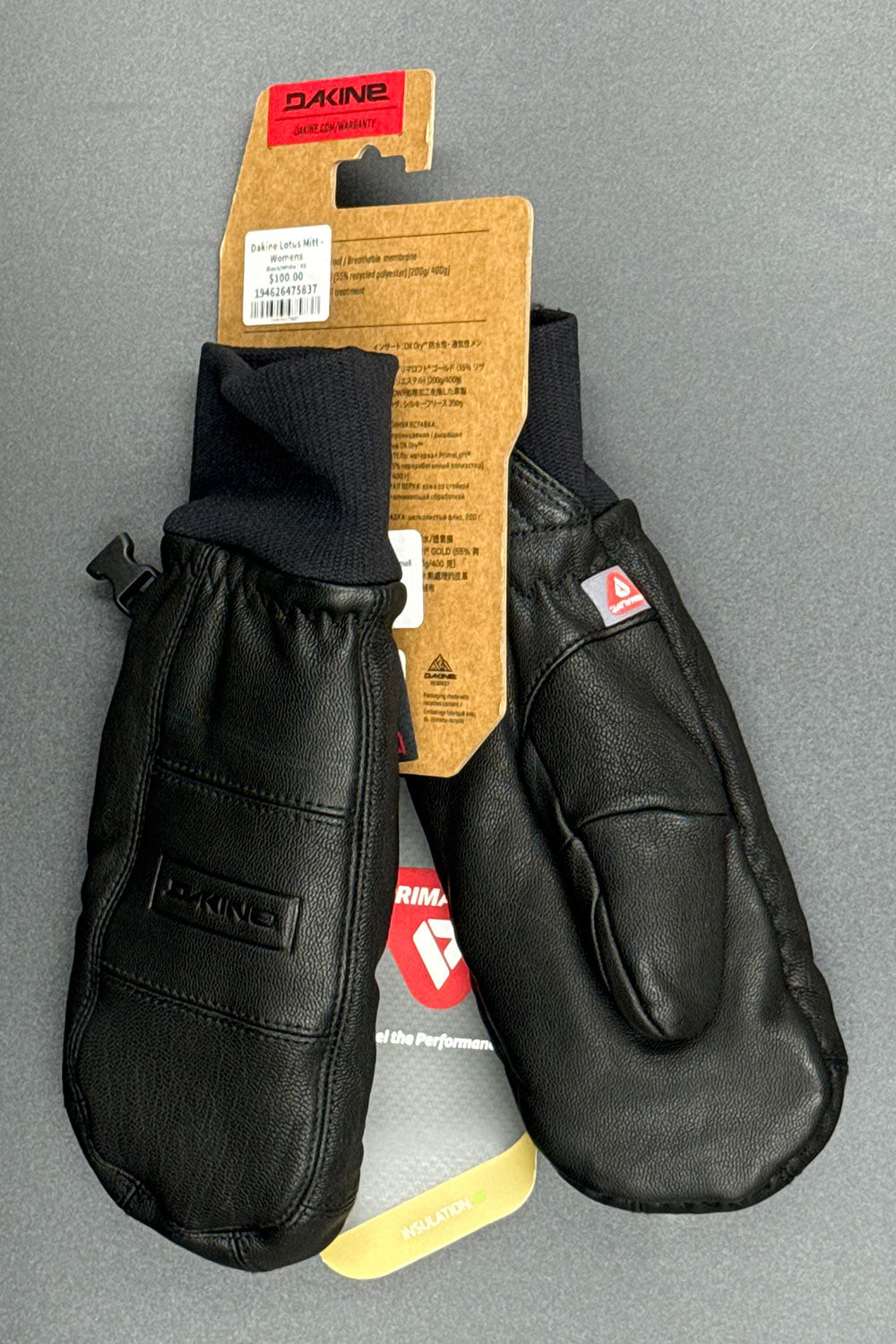 Black mittens with Dakine branding on a gray background