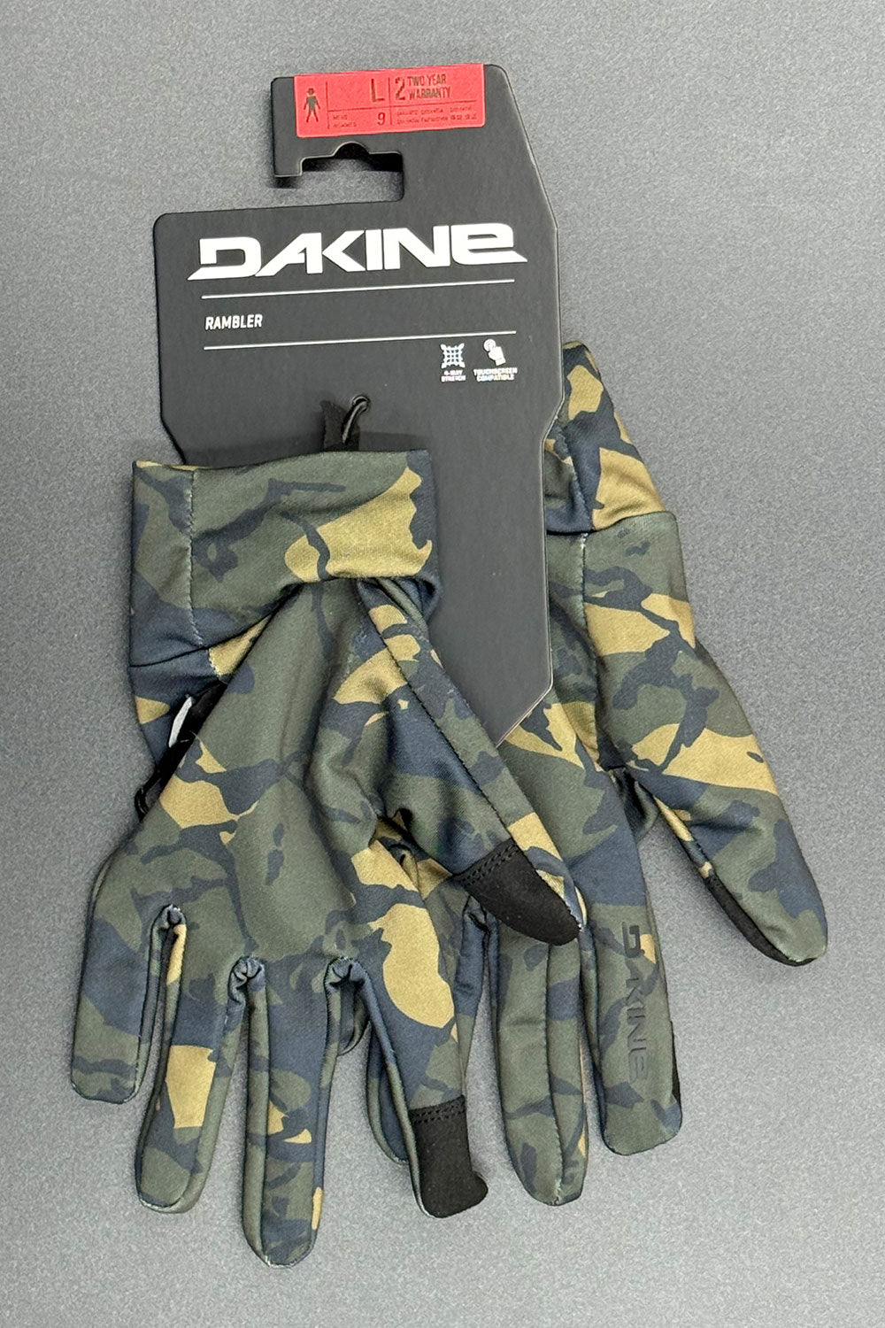 Camouflage gloves with Dakine packaging on a gray background