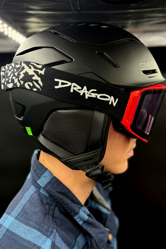 Person wearing a black helmet with 'Dragon' branding on a dark background