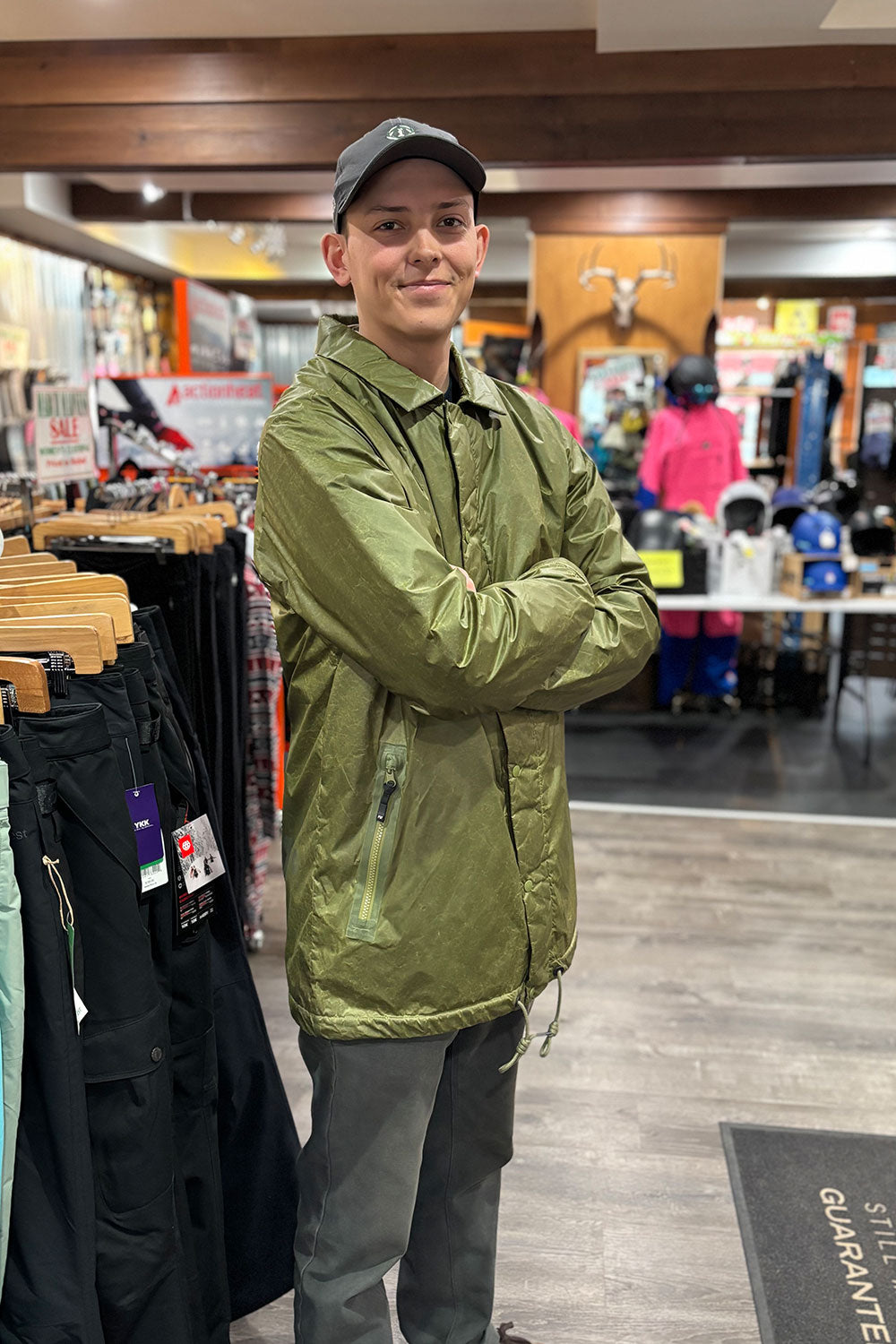 person wearing a green jacket in a shop setting