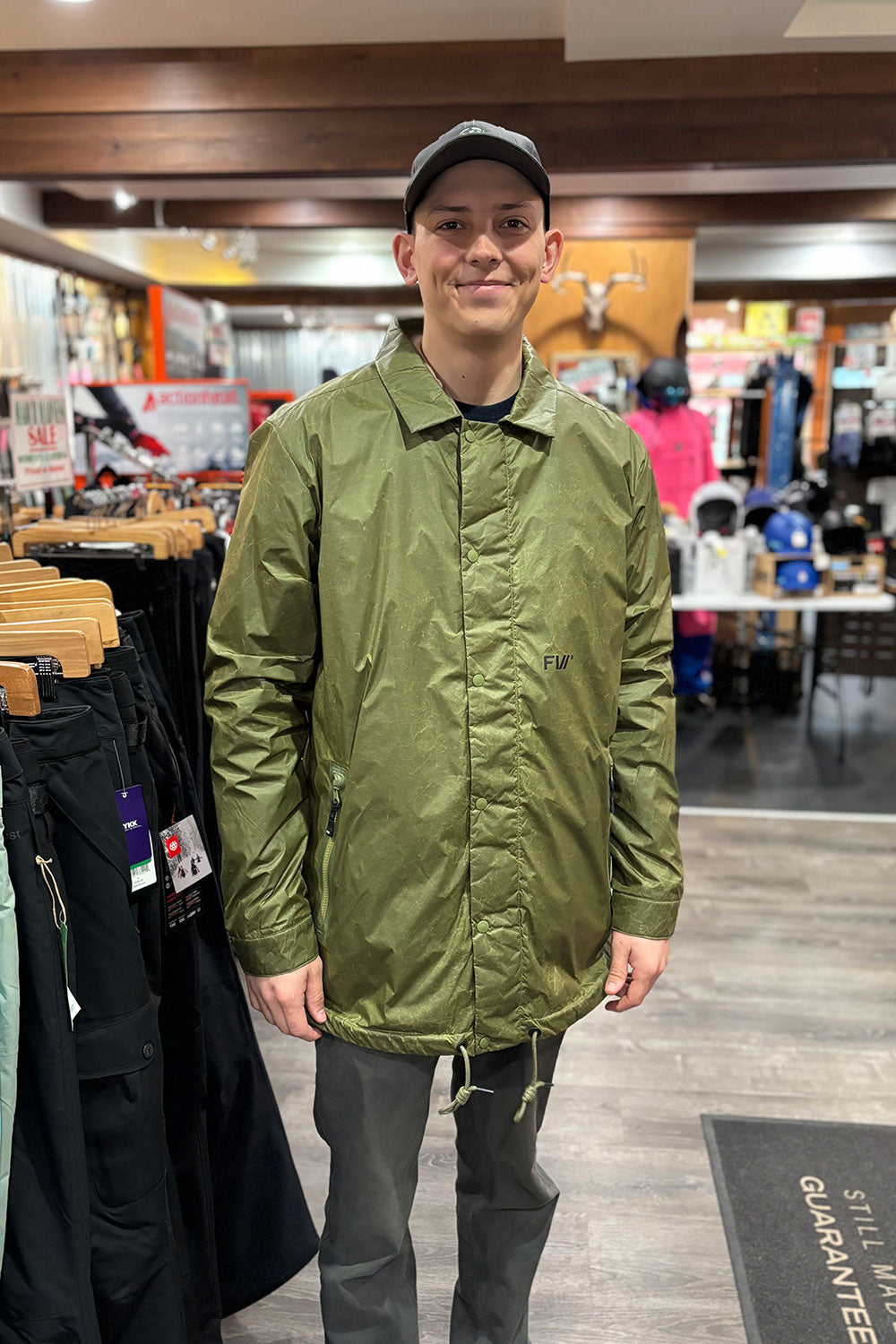 person wearing a green jacket in a shop setting
