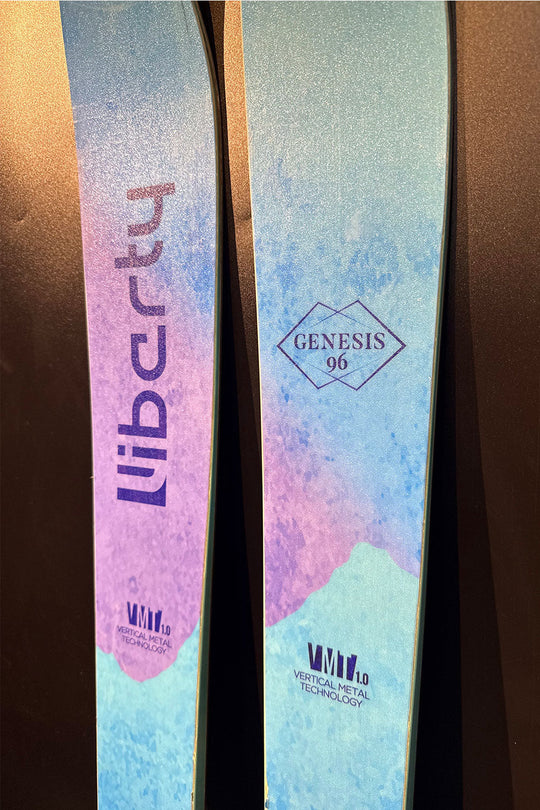 Two skis with 'Liberty' and 'Genesis' branding on a dark background