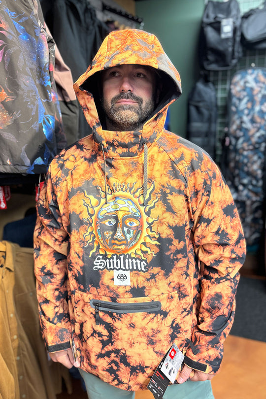Person wearing a colorful hoodie with a brand logo in a store setting