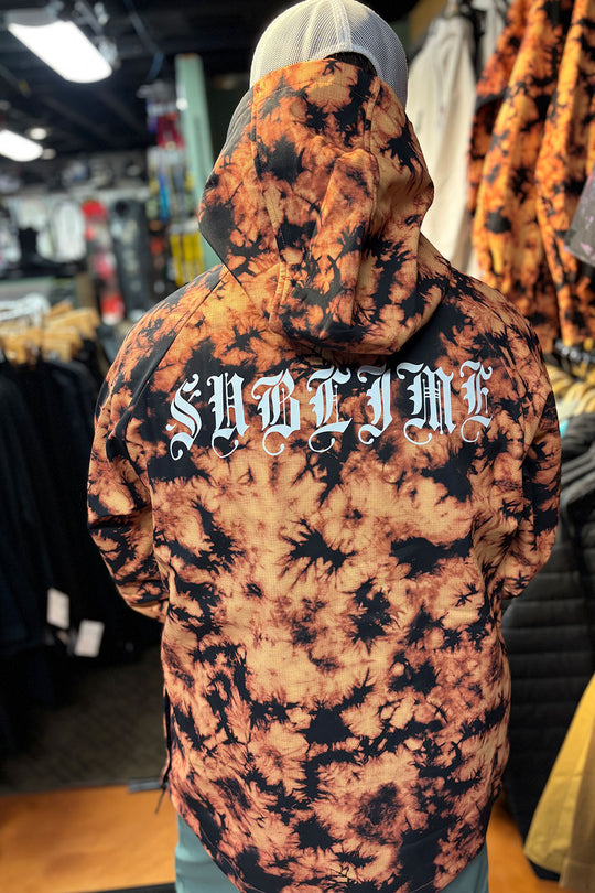 Person wearing a tie-dye hoodie with 'Sublime' text in a store setting