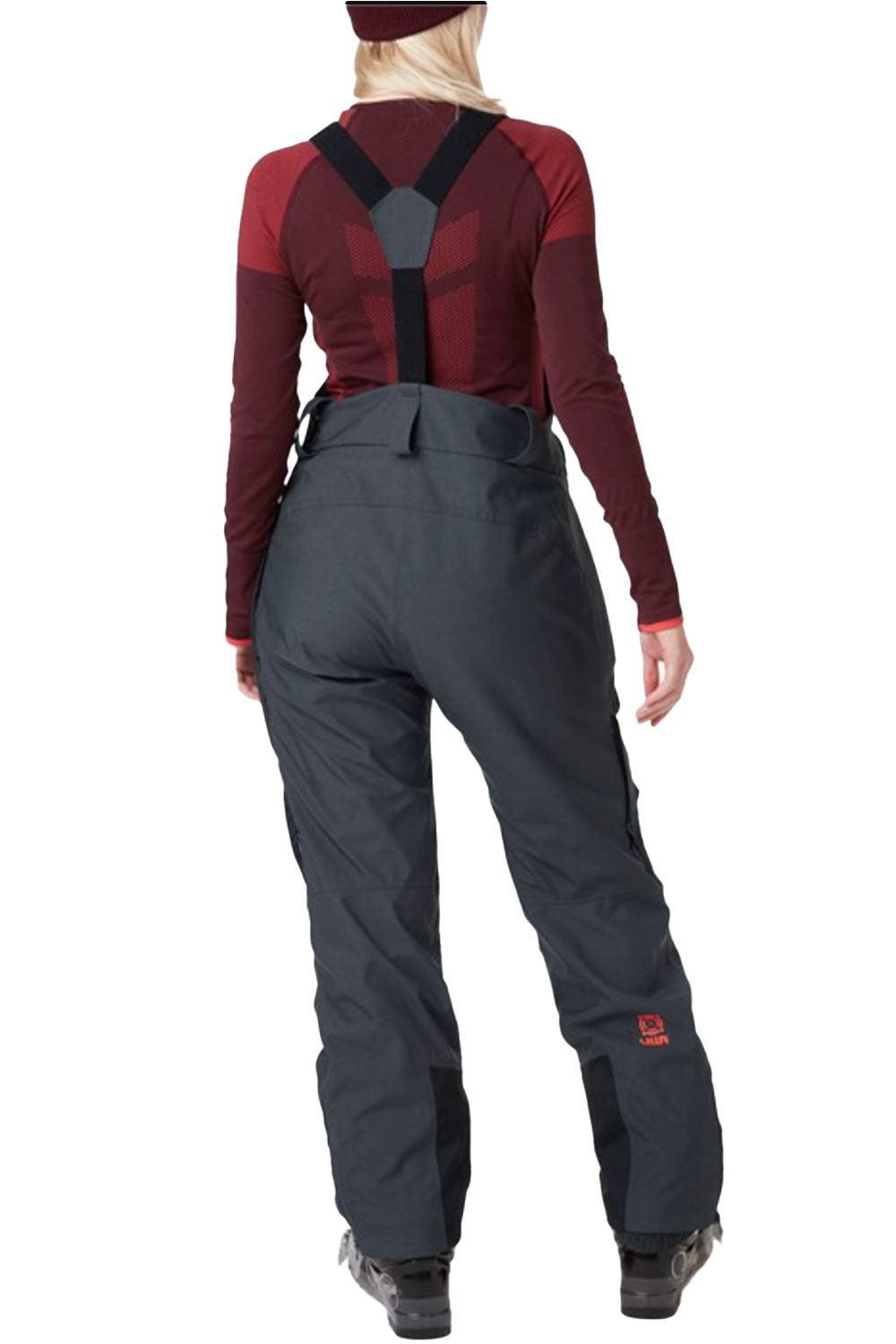 Person wearing a maroon top and navy bib overalls on a white background