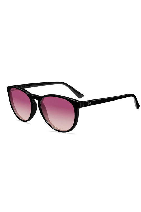 Black sunglasses with pink gradient lenses on a white background
