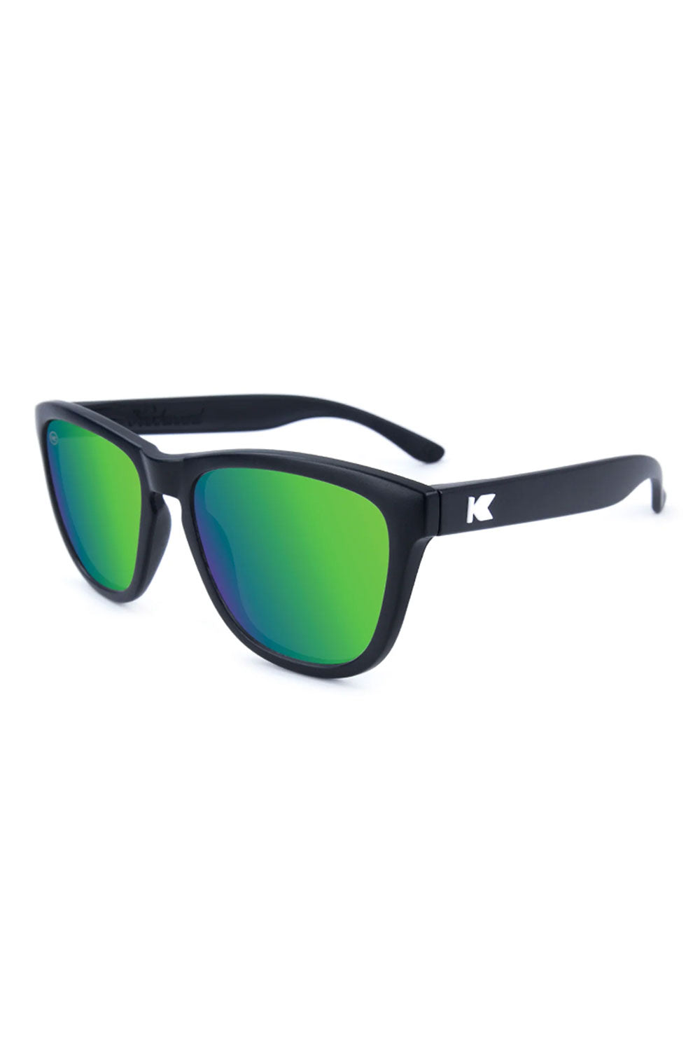 Black-framed sunglasses with green lenses on a white background