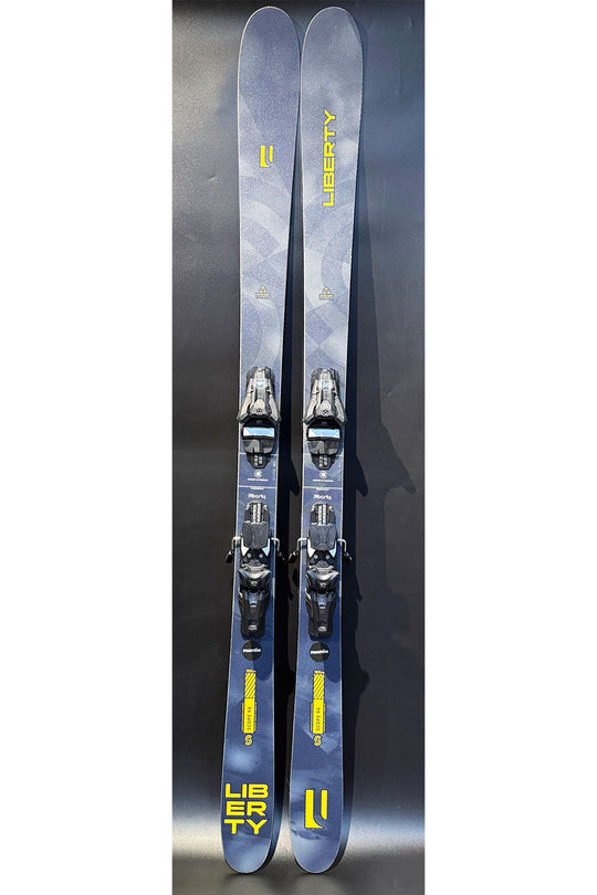 Two skis with bindings on a dark reflective surface