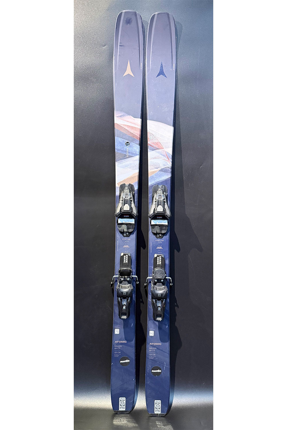 Pair of blue skis with bindings on a dark background