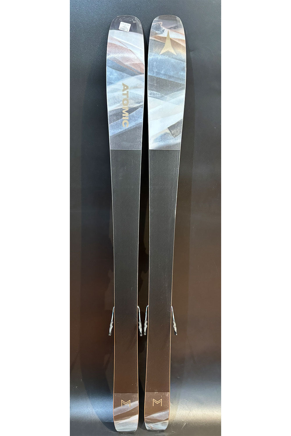 Two skis with a brand logo on a reflective surface
