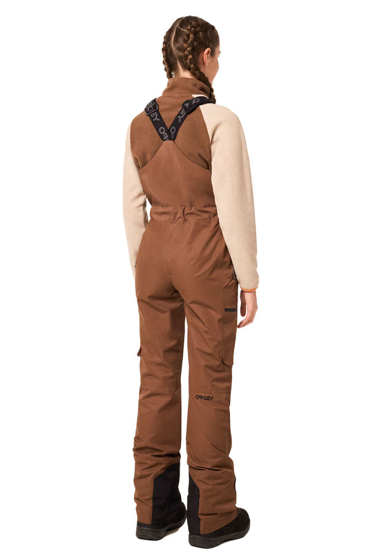 Person wearing brown bib overalls on a white background