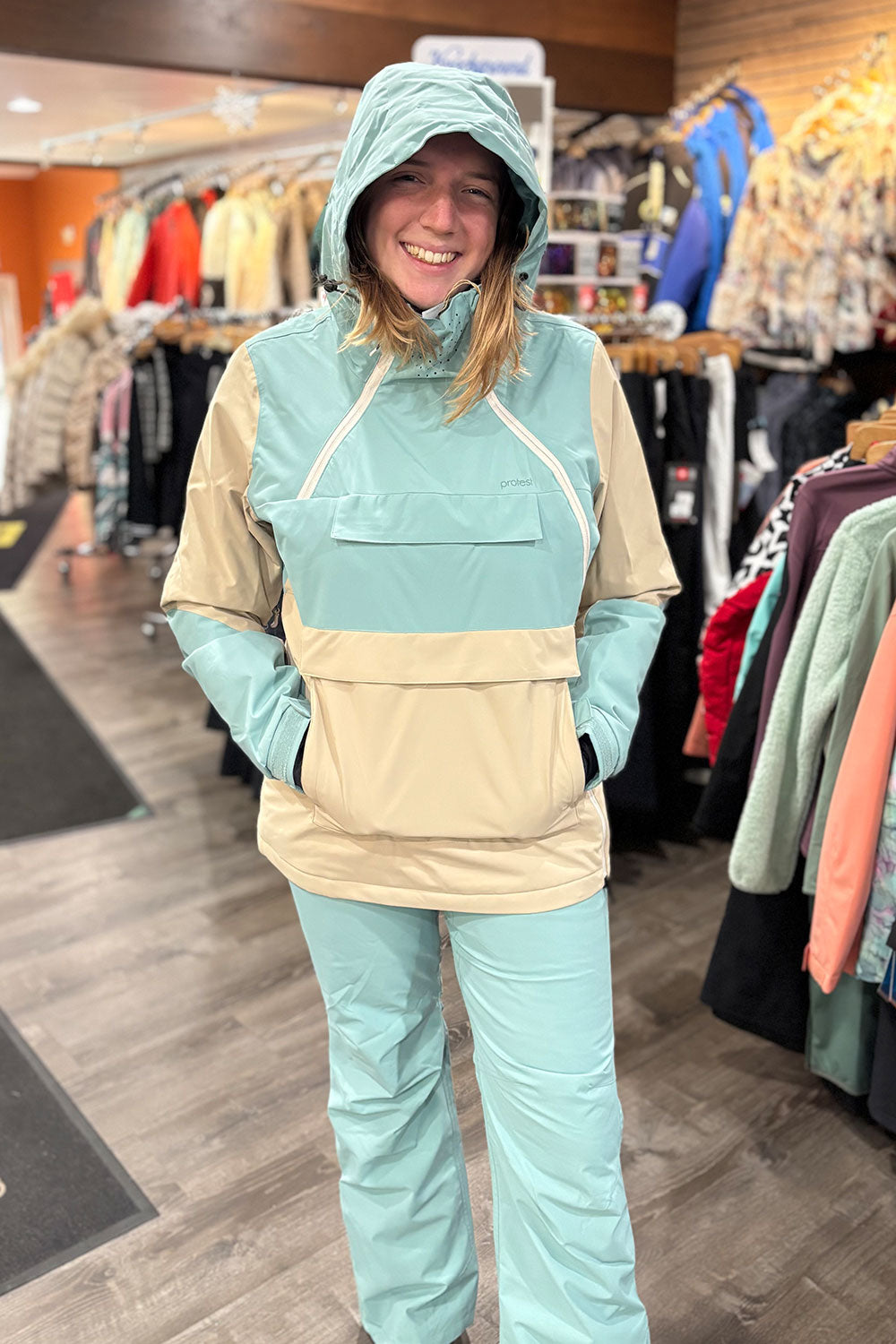 Person wearing a teal and beige snowsuit in a store setting