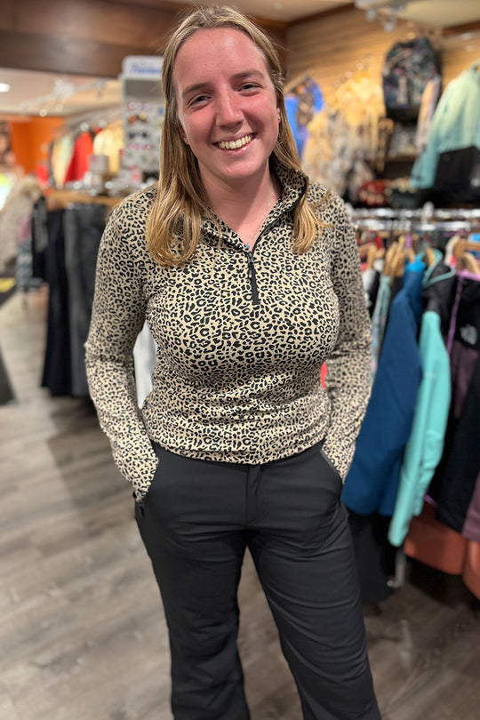 Woman wearing a leopard print top in a store setting