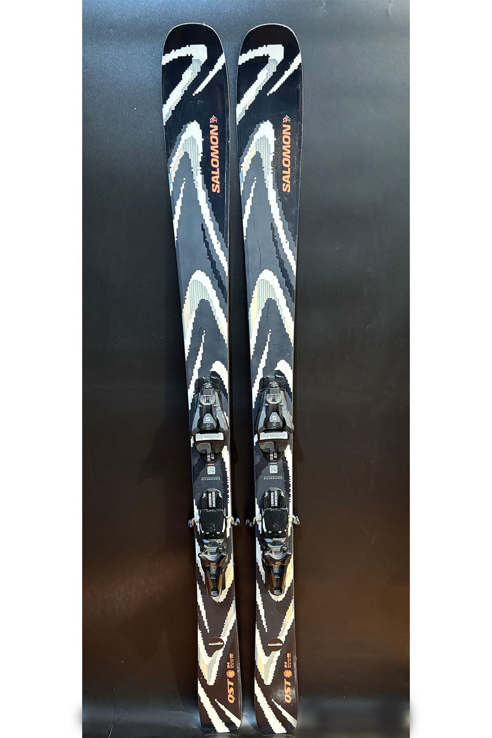 Pair of Salomon skis with bindings on a dark background