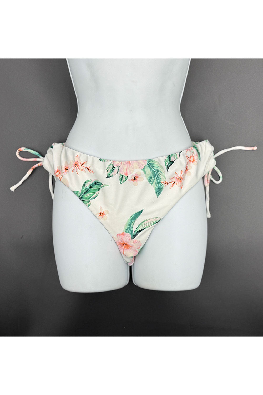 Floral patterned bikini bottom on a mannequin against a gray background