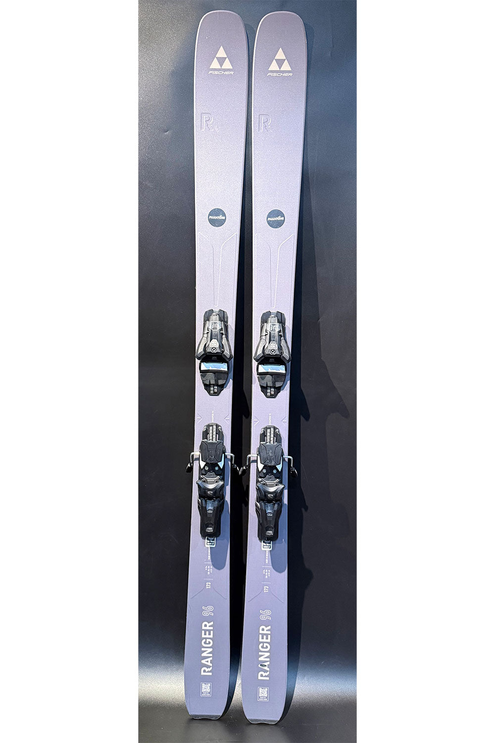Pair of skis with bindings on a reflective surface