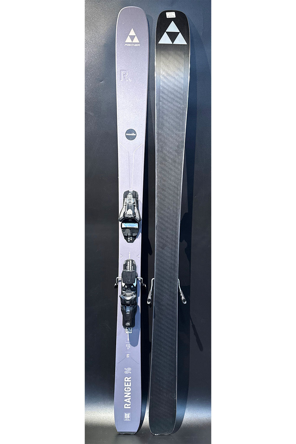 Two skis with bindings on a gray background