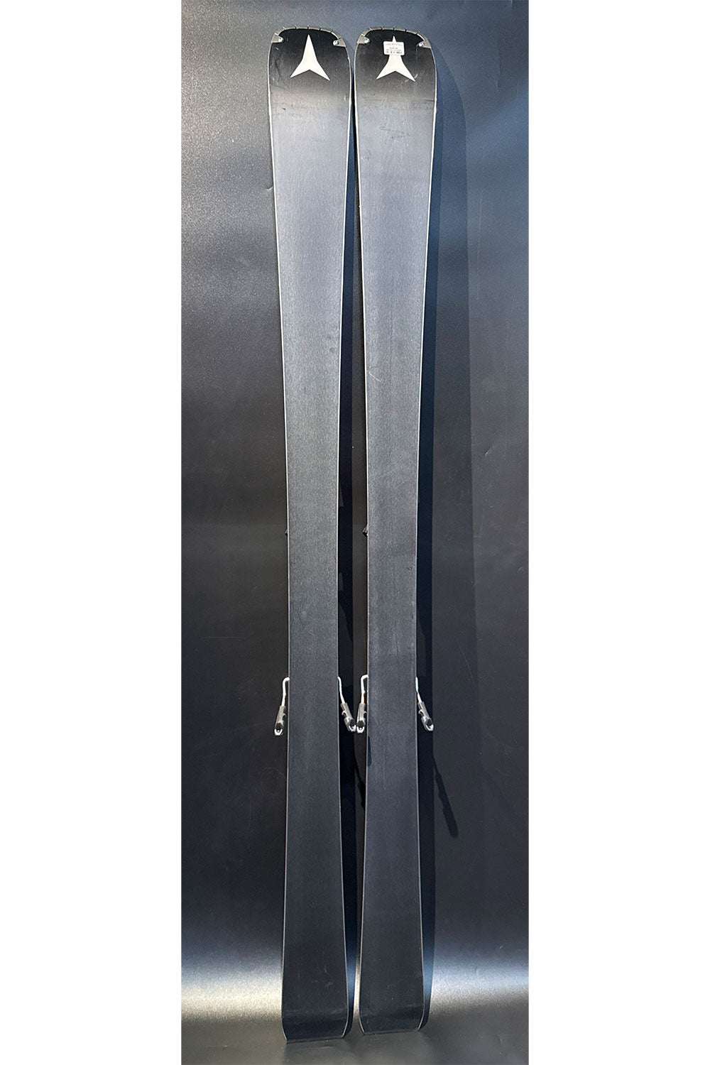 Pair of skis with visible branding on a dark background