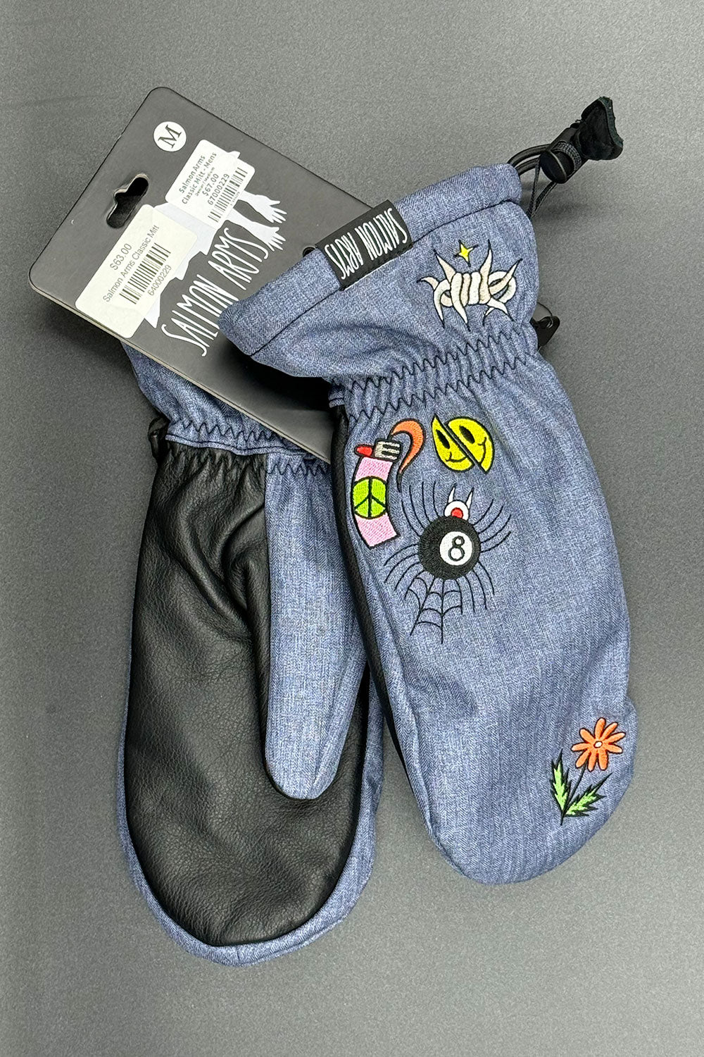 Blue mittens with colorful designs on a gray background