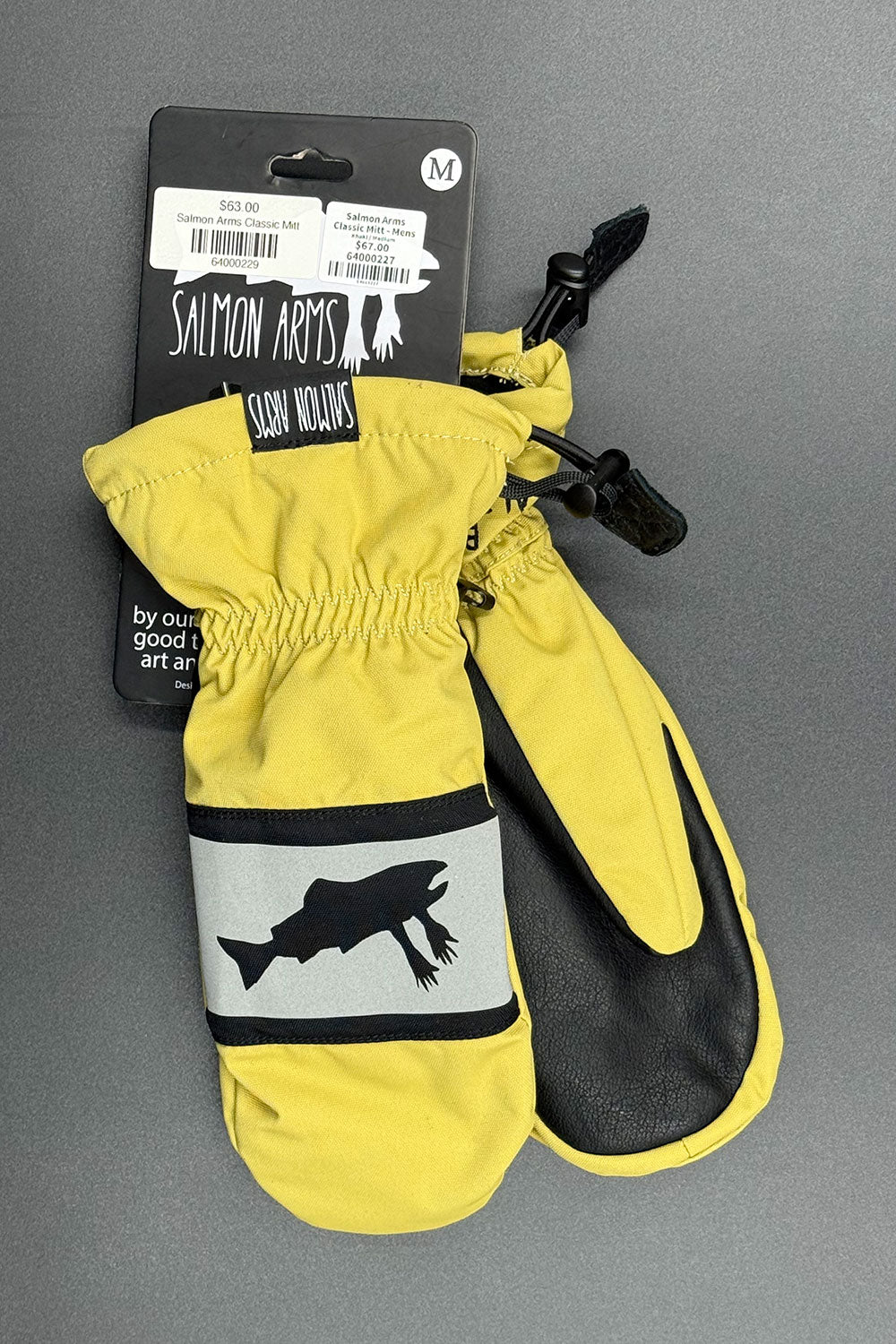 Yellow and black mittens with a fish logo on a gray background