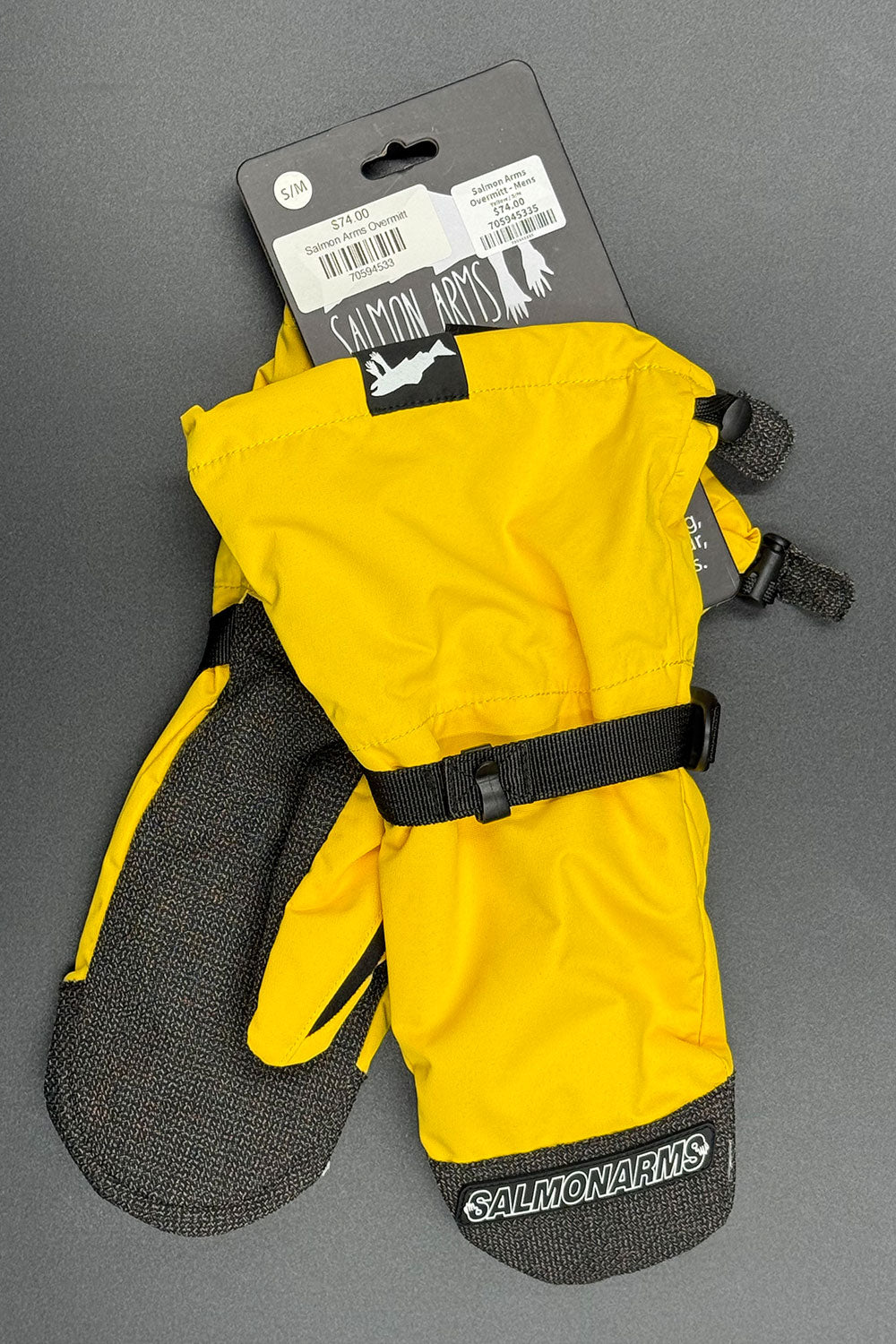 Yellow and black Salmon Arms ski mittens on a gray background