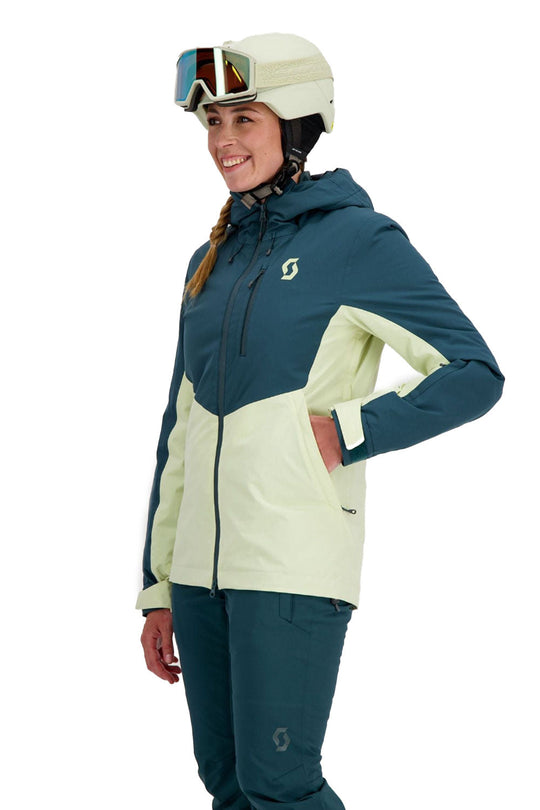 Person wearing a blue and yellow ski jacket with goggles on a white background