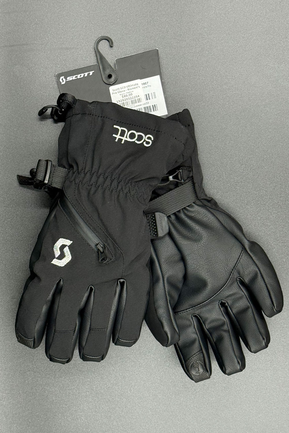 Pair of black gloves with Scott logo on a gray background