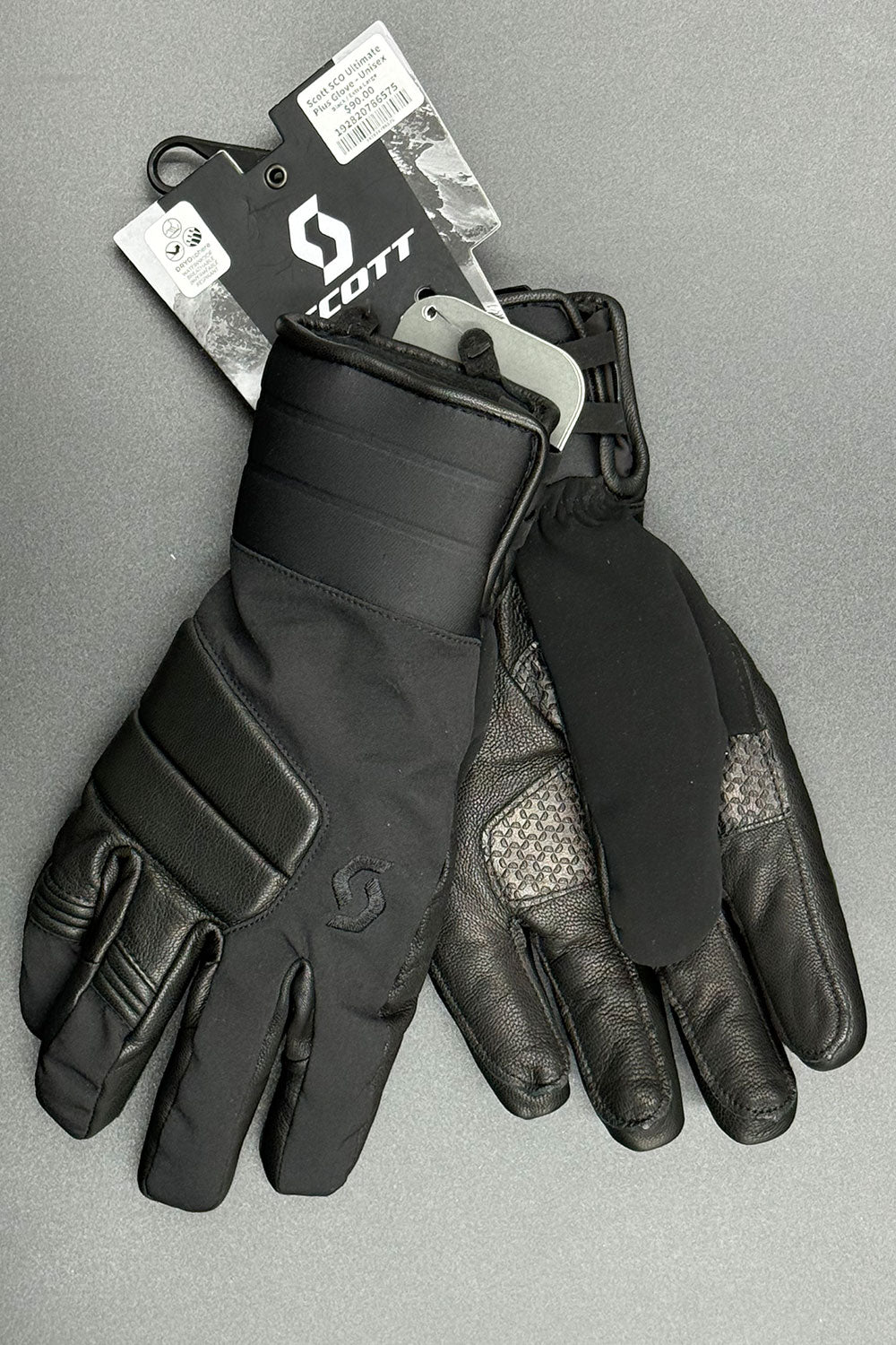 Pair of black gloves with a Scott tag on a gray background