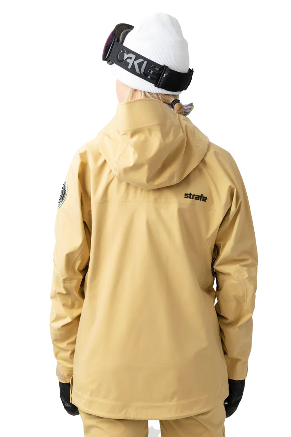 Person wearing a beige jacket with 'strato' branding on a white background