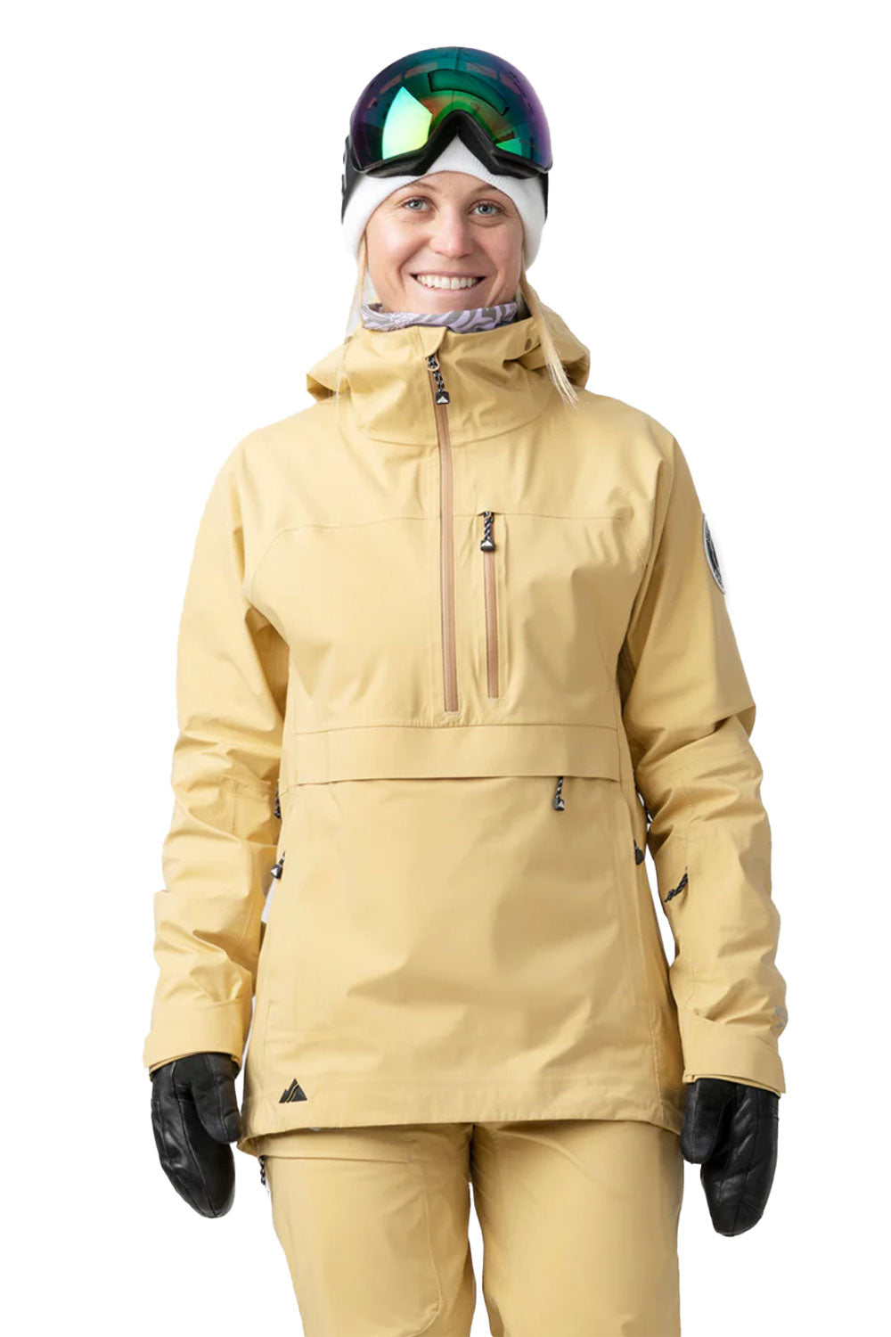 Person wearing a beige snow jacket and pants with goggles on a white background