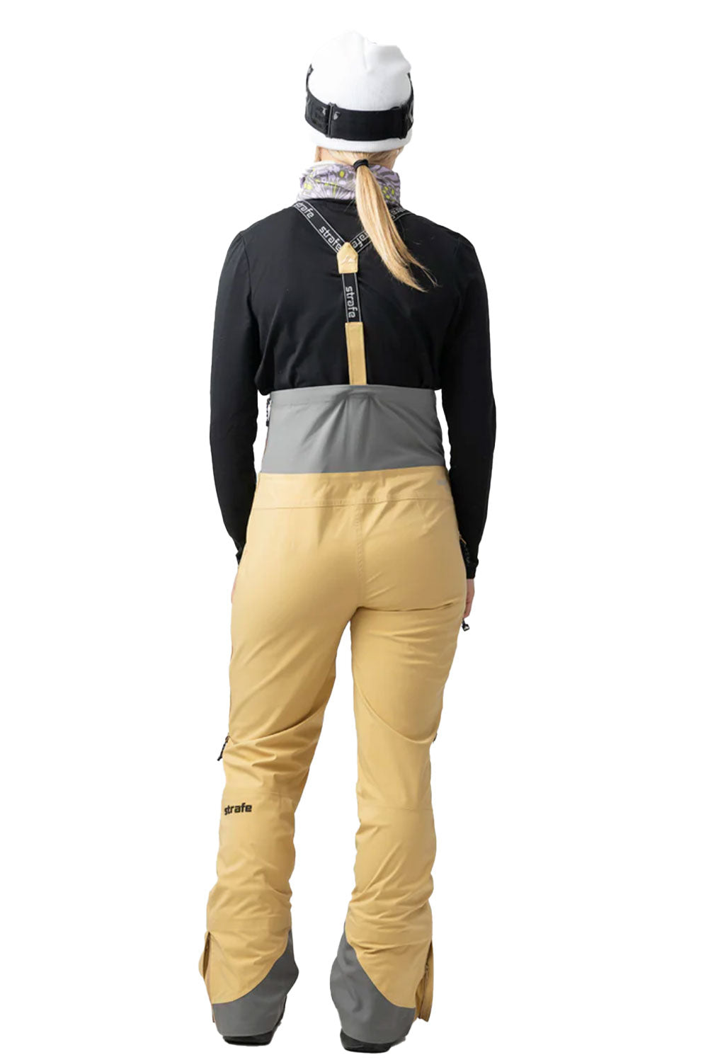 Person wearing a black jacket, gray waistband, and beige pants on a white background