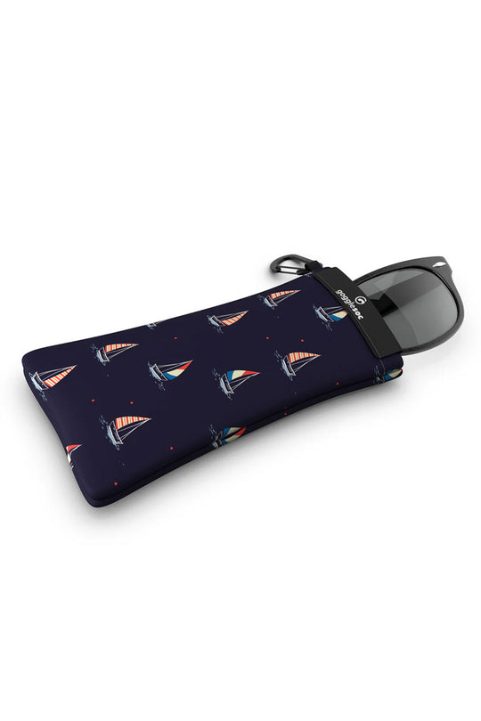 Sunglasses in a navy pouch with sailboat pattern on a white background